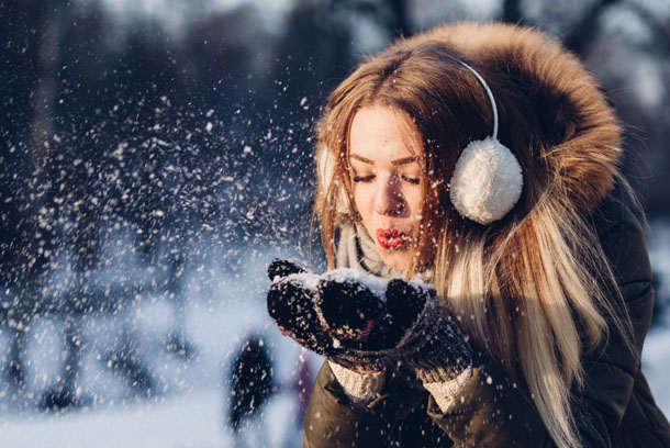 Новорічна картинка з дівчиною, що сдуває сніг